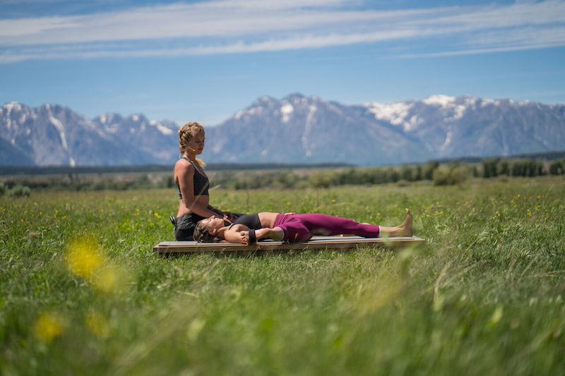 a woman doing yoga does a hamstring stretch with a strap