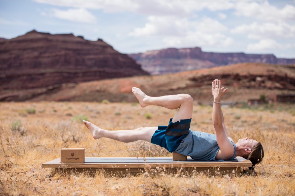 man practices a bridge pose modification to strengthen the core 