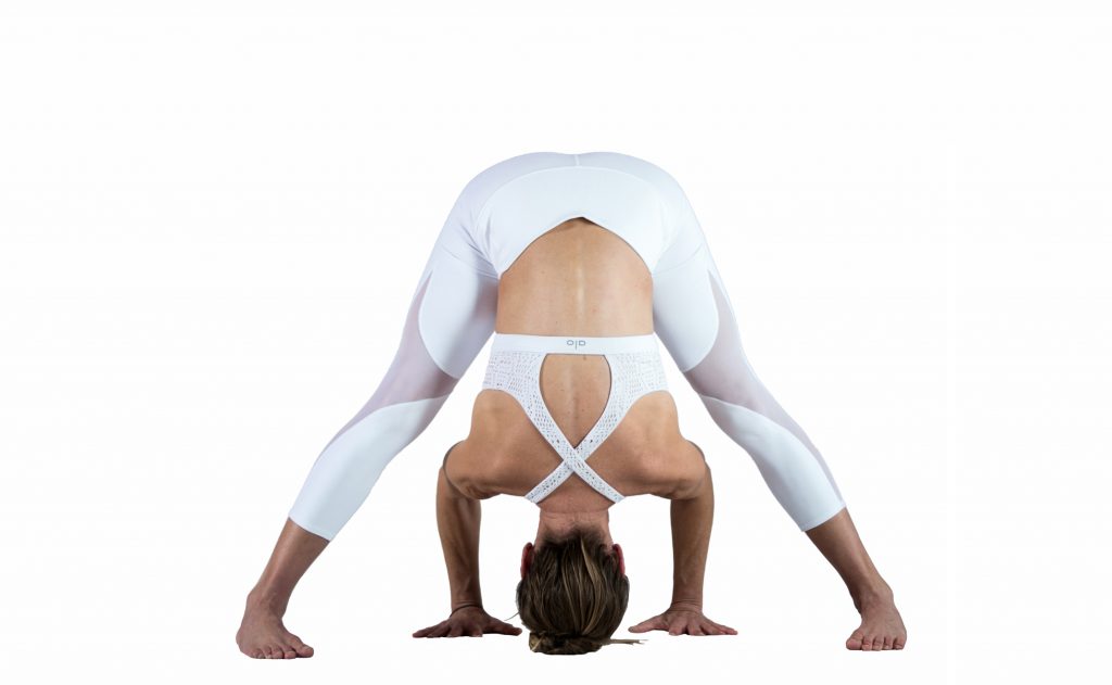 woman practices wide legged forward fold yoga pose -yogatoday 