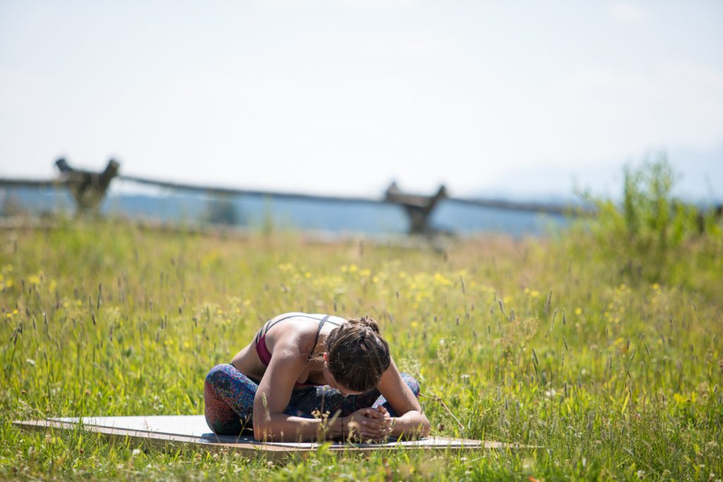 woman stretches outdoors in Grand Teton National Park- YogaToday