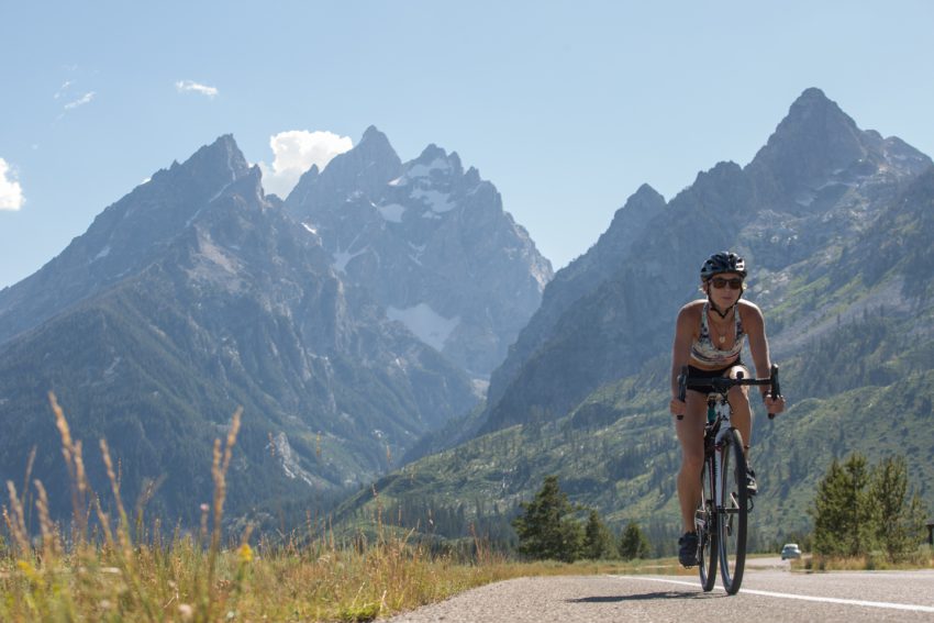 woman cycles in Grand Teton National Park - yogatoday