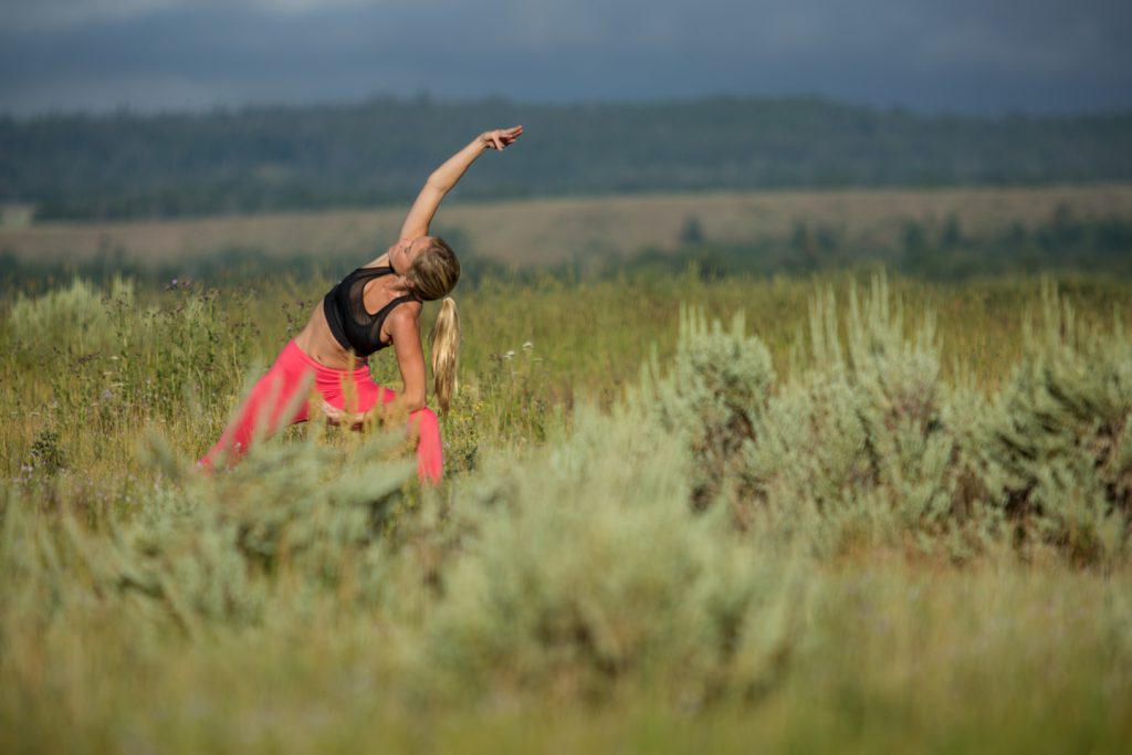 yogi practices side angle pose outdoors - yogatoday