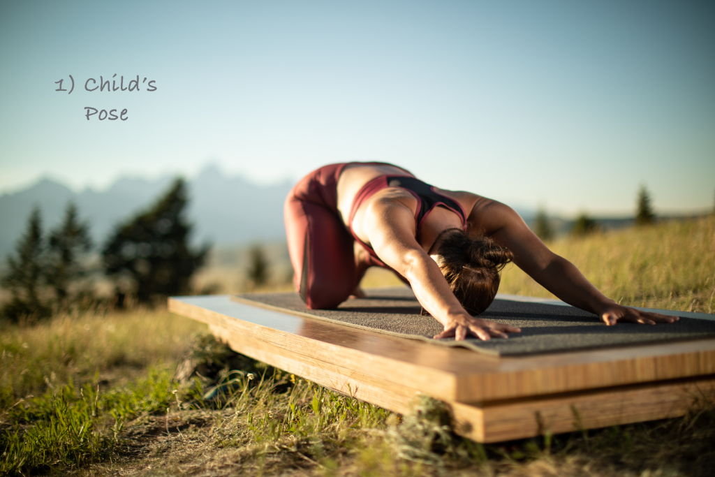 woman practices child's pose on an outdoor yoga platform -YogaToday