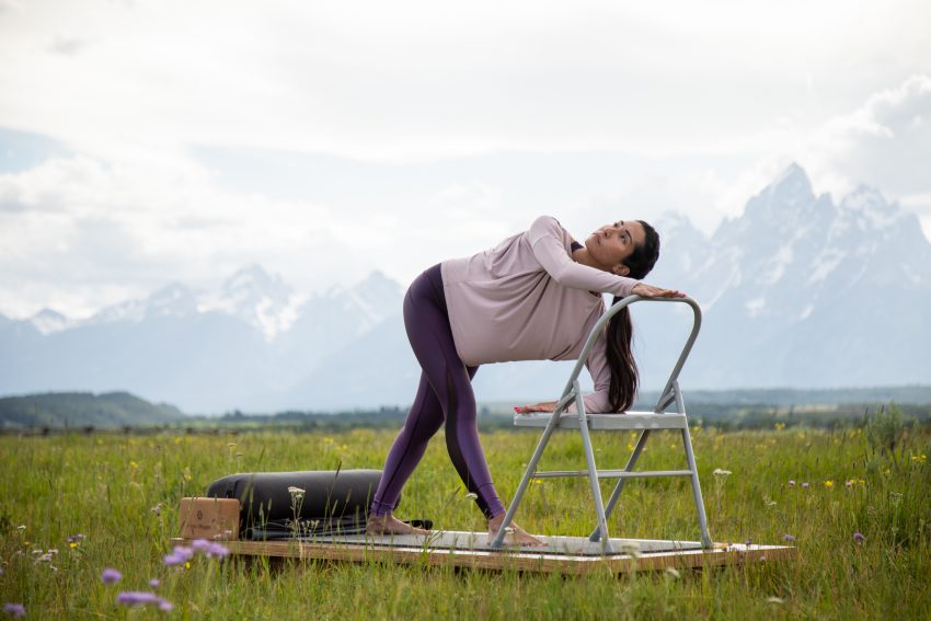 woman practices yoga to relieve neck tension at her desk chair - YogaToday