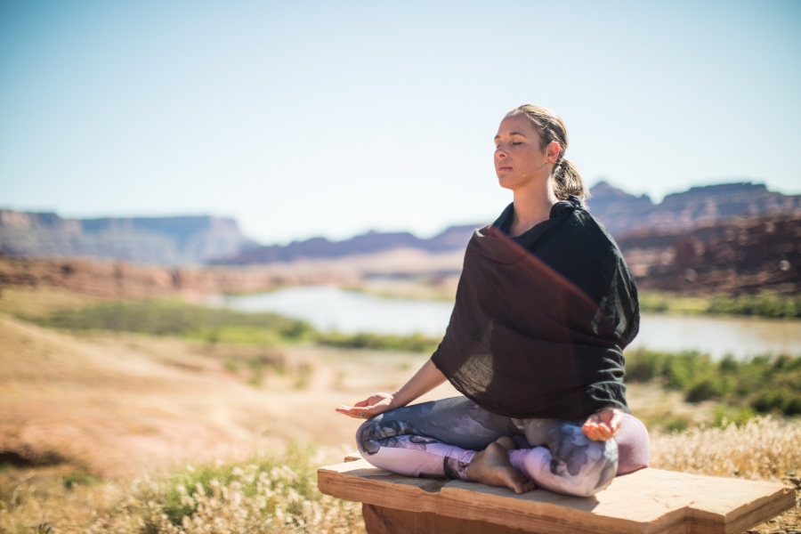 woman meditates in a desert setting