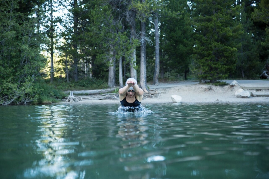 woman swims in string lake in Grand Teton National Park - yogatoday