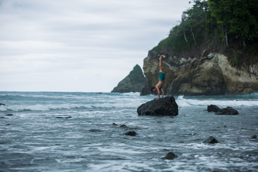man practices yoga on a tropical coastline - yogatoday