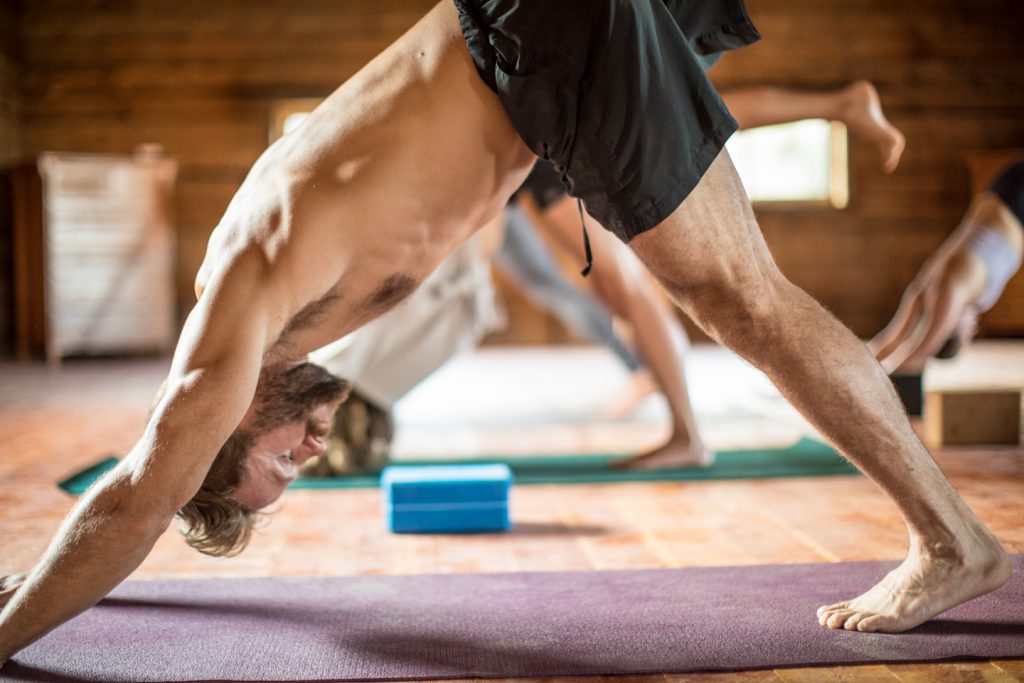 man practices downward dog 