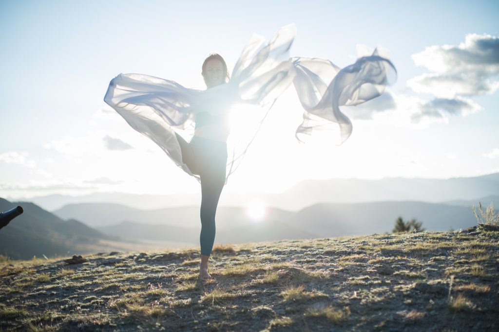 woman practices yoga draped in a white scarf -yogatoday