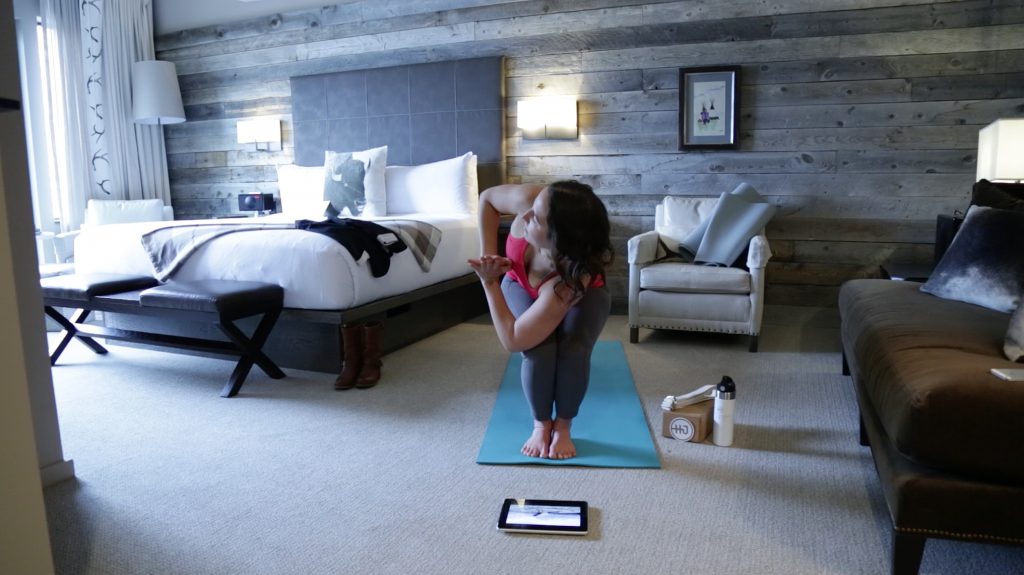 woman practices yoga in a hotel room