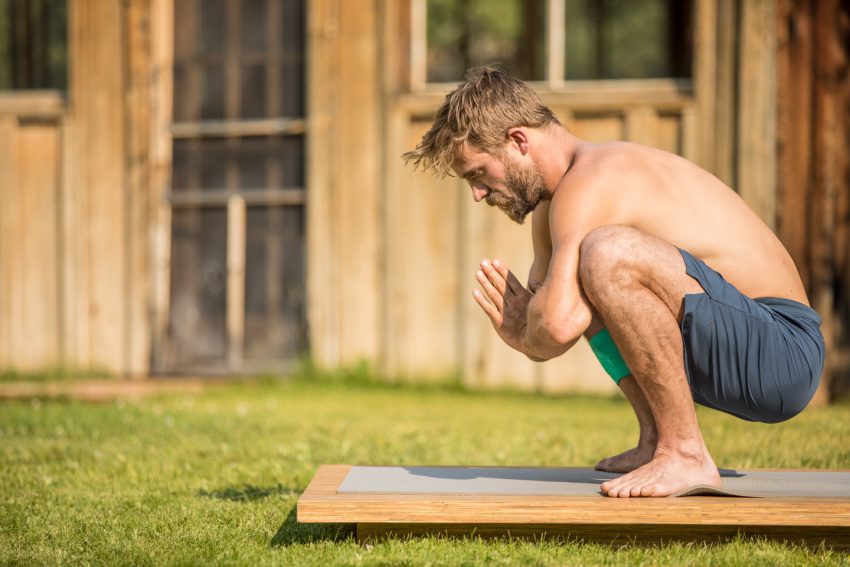 man practices yoga squat for gut health