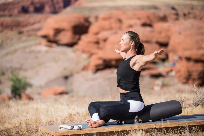 woman extends her arms in a seated yoga pose -yogatoday
