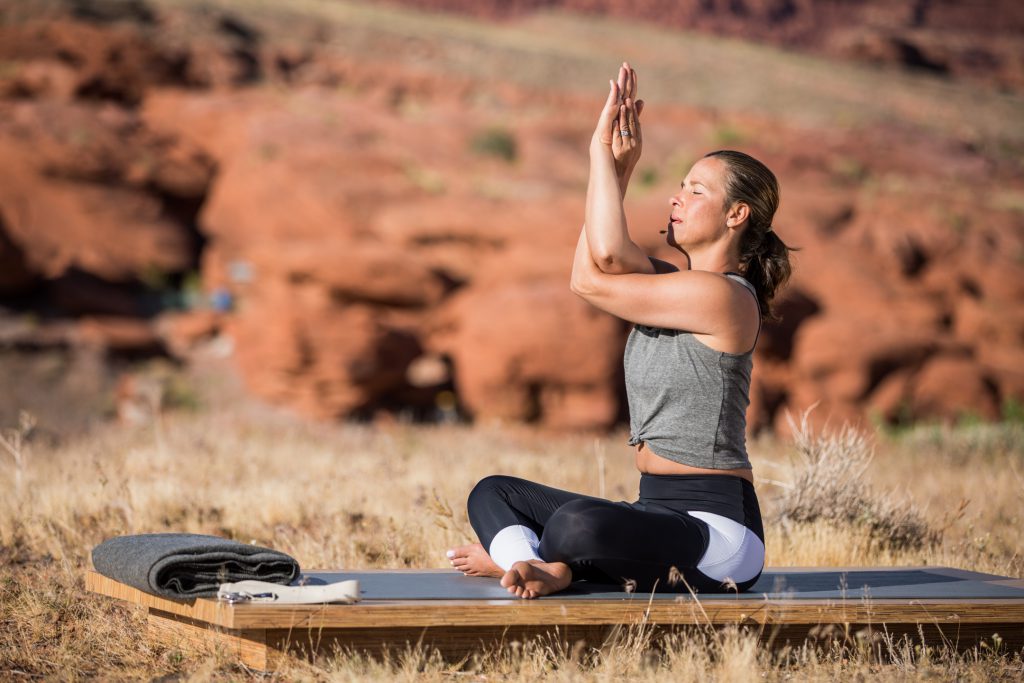 woman practices eagle pose to stretch her shoulders - yogatoday