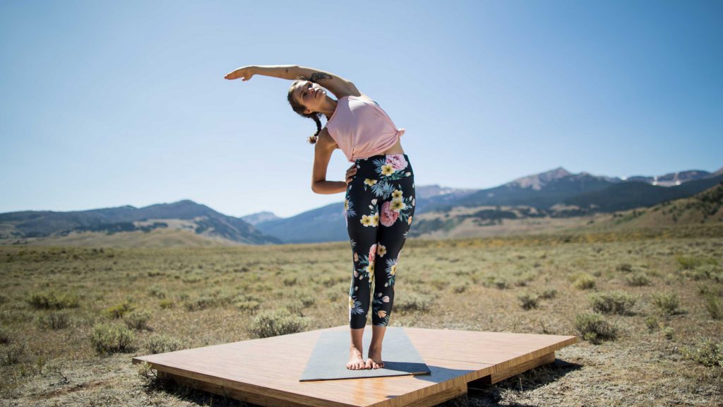 woman practices a spinal side stretch during Pilates class