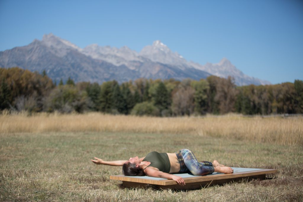 woman practices a reclined spinal twist - yogatoday