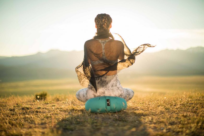 reiki practitioner meditates outdoors at sunset