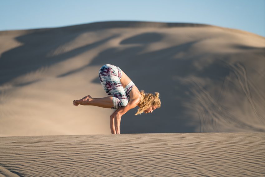 woman practices yoga in the sand dunes of Utah