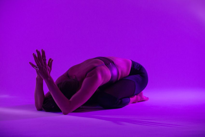 woman practices prayer pose to activate the sixth chakra